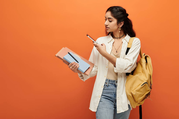 Mujer india joven activa sosteniendo un cuaderno y una mochila. - Foto, Imagen