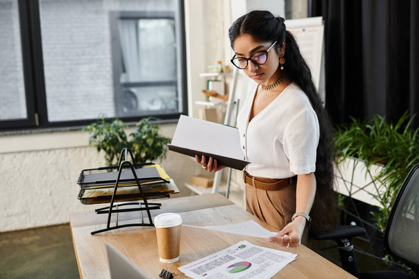 Young indian woman with glasses working at desk with papers. - Photo, Image