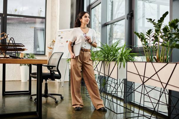 Young indian woman standing among office plants. - Photo, Image