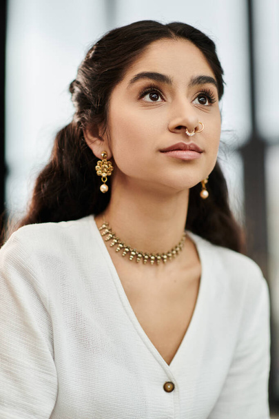 若いインドの女性は誇らしげに彼女のネックレスとイヤリングを紹介します. - 写真・画像