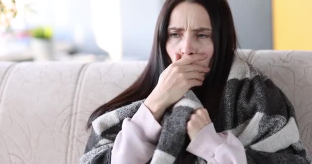 Mulher jovem tosse sob coberturas e tirando o termômetro de seu filme de axila 4k. Tratamento de resfriados em casa conceito - Filmagem, Vídeo