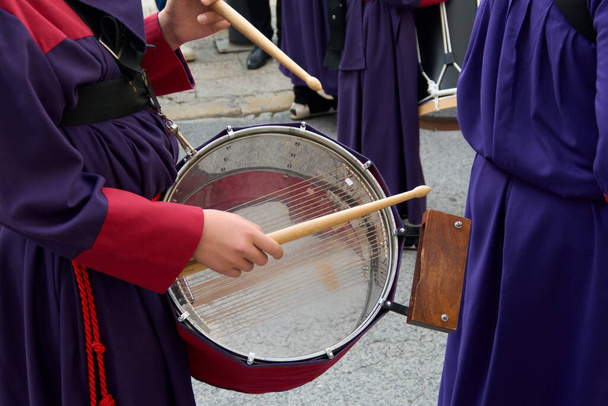 Músicos tocando la batería durante una procesión. Están vestidos con túnicas coloridas que crean una atmósfera vibrante y rítmica que invita a la reflexión y la celebración. - Foto, imagen