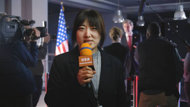 アジアのアンカーウーマンは,政府ビルからニュースを漏らすと報じている. 女性ジャーナリストがアメリカの政治家やアメリカ大統領との記者会見から政治番組の放送をリード - 写真・画像