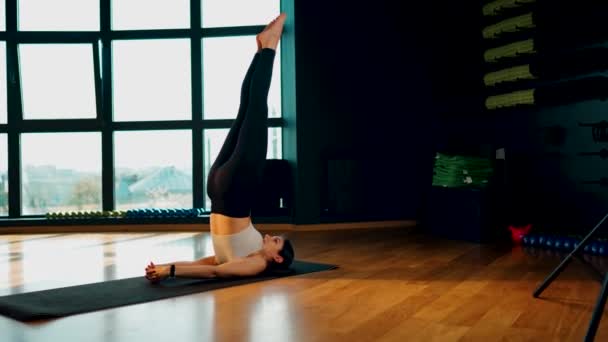 Jonge atletische vrouw is bezig met fitness en doet yoga in de gym.Yoga en fitness.Gezond levensstijl concept 4k - Video