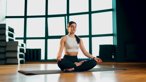 Jeune femme athlétique est engagé dans la forme physique et fait du yoga dans la gymnase Yoga et fitness Concept mode de vie sain 4k - Séquence, vidéo