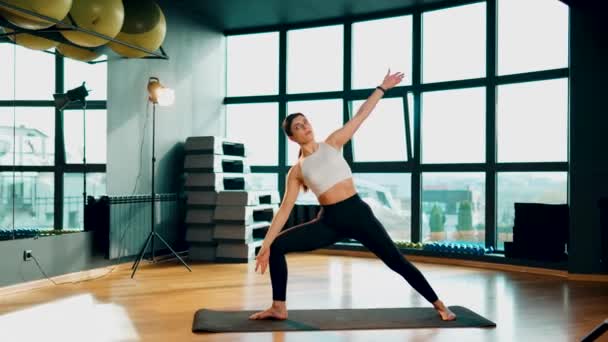 Mujer atlética joven se dedica al fitness y hace yoga en el gimnasio.Yoga y fitness.Healthy concepto de estilo de vida 4k - Imágenes, Vídeo