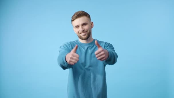 Virágzó jóváhagyás: a kék inges férfi felemeli a hüvelykujját - Felvétel, videó