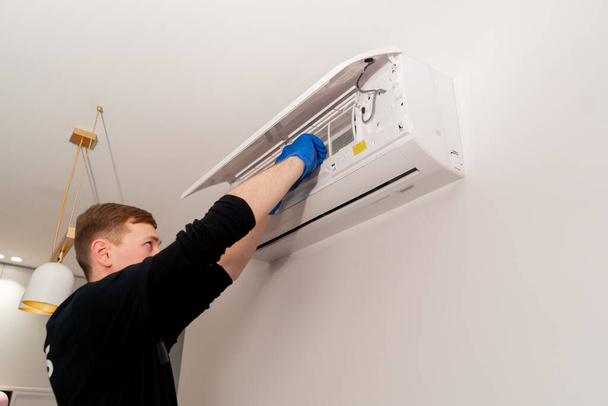 asunnossa siivooja puhdistaa suodattimia ilmastointilaitteessa täyttämällä jäähdytin - Valokuva, kuva