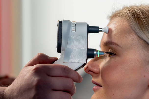 Nahaufnahme in einer Augenklinik: Ein junges Mädchen überprüft den Druck des Augapfels - Foto, Bild