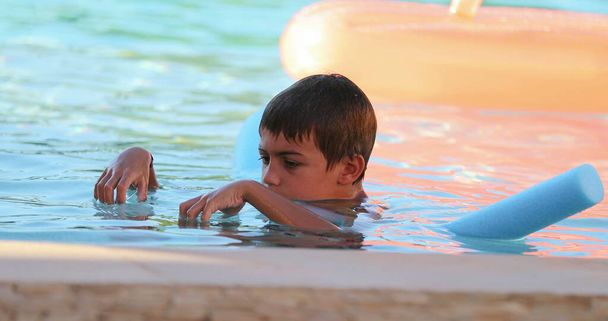 Malý chlapec hrát s plavání pomoc plovoucí nudle - Fotografie, Obrázek