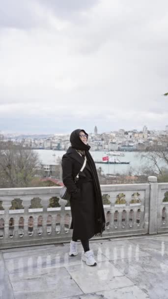 Μια μοντέρνα γυναίκα ποζάρει με τον ιστορικό ορίζοντα της Κωνσταντινούπολης από το παλάτι Τοπ Καπί.. - Πλάνα, βίντεο