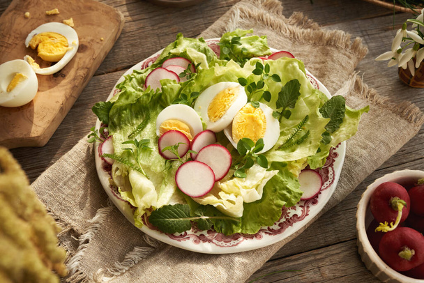 Une assiette de salade de légumes de printemps avec des œufs et des plantes comestibles sauvages - potamot, tétranyque et achillée - Photo, image