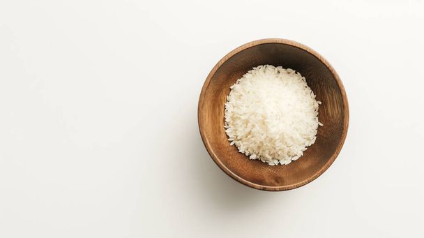 Δοχείο λευκού ρυζιού σε καθαρή λευκή επιφάνεια, πάνω όψη. - Φωτογραφία, εικόνα