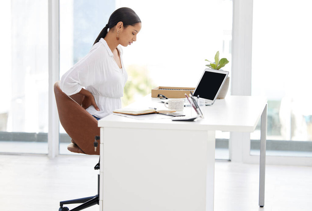 Back pain, laptop and business woman in office with stress, injury or accident for medical emergency. Burnout, computer and professional female designer with spine muscle sprain by desk in workplace - Photo, Image