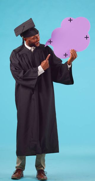 Black man, graduate and pointing at speech bubble for success, recruitment, blue background. Student, graduation and portrait with male person with promotion or announcement, sign up with happiness - Photo, Image