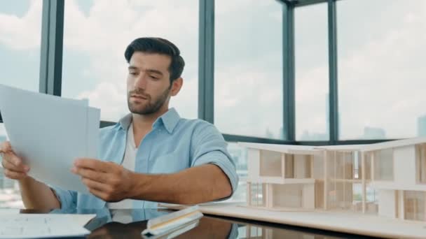 Portrait of skilled engineer checking blueprint while think about house design. Professional businessman choosing project while looking at architect model and writing, drawing, drafting. Disputation - Footage, Video