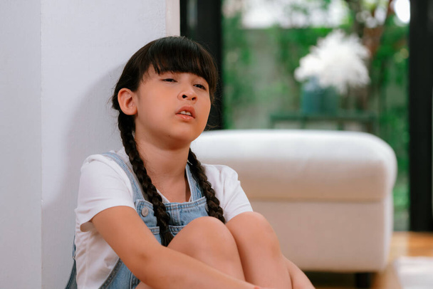 Λυπημένο κοριτσάκι που κάθεται μόνο στο σαλόνι κλαίγοντας, νιώθοντας μοναξιά. Νεαρό κορίτσι που βιώνει την κοινωνική τιμωρία απομόνωσης ή παραμέληση από τους γονείς οδήγησε σε άγχος και τραυματική εμπειρία στην παιδική ηλικία. Συγχρονισμός: - Φωτογραφία, εικόνα
