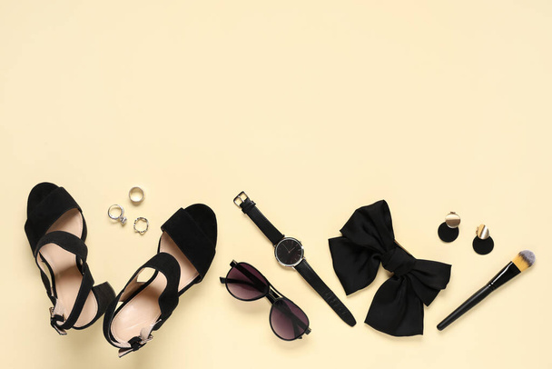 Сандалии на черных каблуках, солнечные очки и лук на бежевом фоне - Фото, изображение