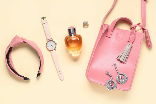 Обручка для волосся, рожевий мішок і пляшка парфумів на бежевому фоні - Фото, зображення