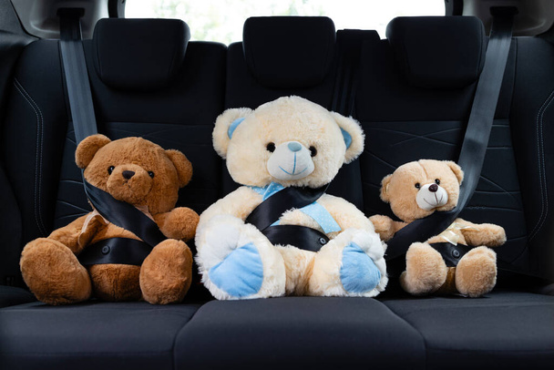 Concepto de seguridad para niños. Juguetes de oso de peluche con cinturón de seguridad para niños mientras conduce. - Foto, imagen