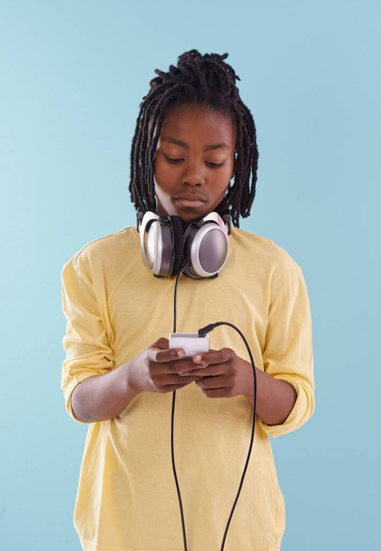 Müzik, kulaklık ve siyah çocuk stüdyoda internet, müzik listesi ya da mavi arka planda iz araması için. Smartphone, radyo ve Afrikalı ergen çocuk podcast, canlı yayın ya da abonelik için başvuru. - Fotoğraf, Görsel