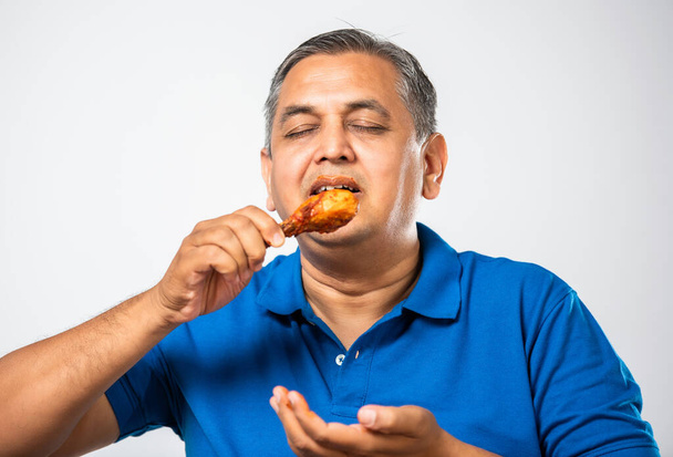 Ασιάτης μεσήλικας που τρώει τηγανητό κοτόπουλο - Φωτογραφία, εικόνα