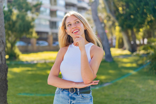 Jeune femme blonde en plein air Avec une expression heureuse - Photo, image