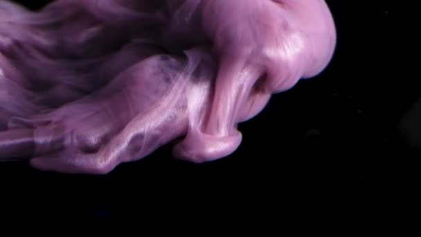 Een close-up weergave van de delicate werveling van rook boven een bed van levendige roze texturen. - Video