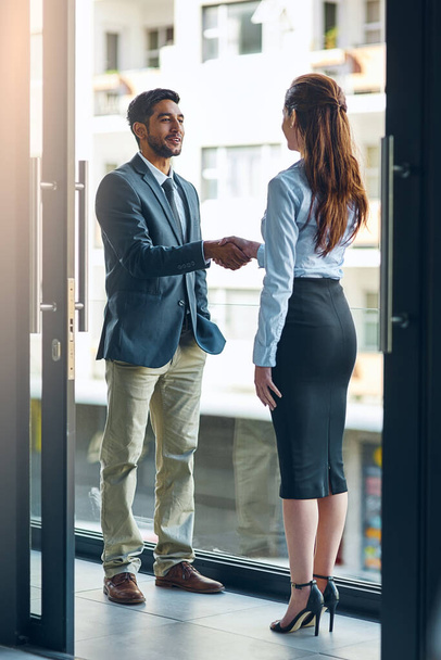 Handshake, meeting and business man and woman in office for teamwork, collaboration and partnership. Corporate office, professional and people shaking hands for agreement, b2b deal and thank you. - Photo, Image