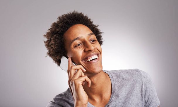 Лицо, телефонный звонок и общение с молодым человеком в студии на сером фоне для разговора. Smile, контакт и технологии со счастливым молодым человеком, говорящим по мобильному телефону для чата или связи. - Фото, изображение