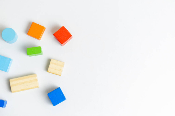 Photo de blocs de bois de style Montessori colorés pour le développement des enfants sur fond blanc, vue de dessus, espace de copie au sommet - Photo, image