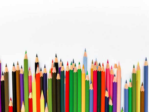 Různé barevné tužky seřazené na bílém pozadí s prostorem pro text. Tvůrčí koncept pro umělecké, vzdělávací a designové reklamní bannery pro školní výrobky s prázdným prostorem. Kvalitní fotografie - Fotografie, Obrázek