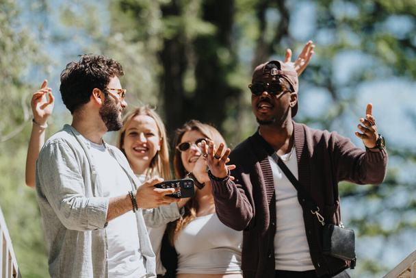 Eine fröhliche, multikulturelle Gruppe von Freunden teilt Lachen und Geschichten in einem sonnigen Park und drückt Glück und Zusammengehörigkeit an einem perfekten Frühlingstag aus. - Foto, Bild