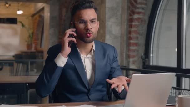 Stressaantunut arabialainen liikemies väittäen älypuhelin soittaa toimistossa vihainen intialainen liikemies työnantaja negatiivisia tunteita raivoissaan vihainen vihainen mies riitaa konflikti puhua matkapuhelin huutaa - Materiaali, video