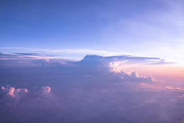 Beautiful sky over clouds at sunset time. An aerial shot above beautiful sunset, sunrise clouds. Sunset above the clouds from airplane perspective. Sky and clouds background - Photo, Image
