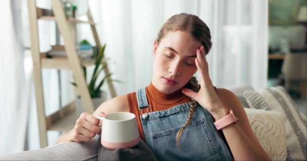 Woman, coffee and thinking with stress on sofa for decision, future or frustrated with drink in home. Girl, person and student with tea on couch with anxiety, idea or worry for exam results in house. - Footage, Video