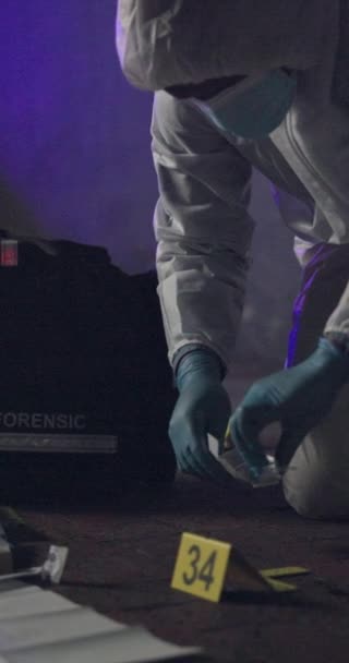 Person, maker and forensic on crime scene, investigation and accident or criminal offence with box for dna sample. Evidence, expert and coveralls, police lights and gloves for protection and night. - Footage, Video