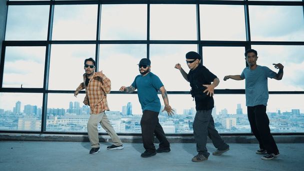 Ομάδα πολυπολιτισμικών χορευτών χορεύουν μαζί με ουρανοξύστη. Πορτρέτο της πολυπολιτισμικής hipster ομάδα κινείται βήμα πόδι με αυτοπεποίθηση κοντά στο παράθυρο με αστικό άποψη της πόλης. Υπαίθριο άθλημα 2024. Ενδεβόρ. - Φωτογραφία, εικόνα