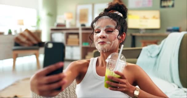 Facial, mask and selfie of girl, face and smile with smoothie, detox and healthy in living room of home. Self love, care and Gen z with phone, memory and post for profile picture, online and app. - Footage, Video