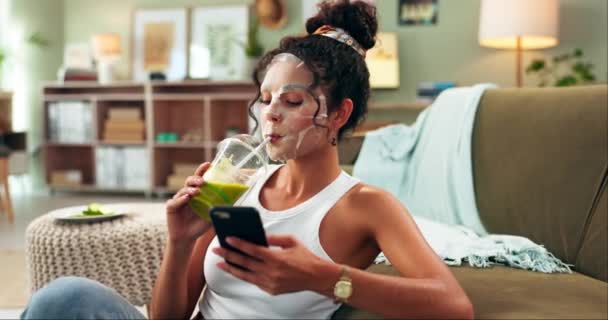 Facial, mask and girl with phone, online and detox with juice or smoothie, drink and care in home. Skincare, cosmetics and beauty for Gen z, woman and mobile on couch, relax and internet on app. - Footage, Video