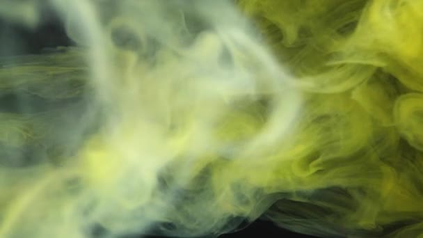 Een close-up weergave van de delicate werveling van rook boven een bed van levendige gele texturen. - Video