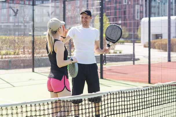  νεαρή γυναίκα παίζει Padel Τένις με συνεργάτη στο υπαίθριο γήπεδο τένις. Υψηλής ποιότητας φωτογραφία - Φωτογραφία, εικόνα