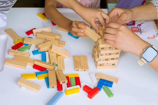 Día Internacional del Niño. Hermosos niños latinos jugando con bloques en una mesa blanca. Juegos lúdicos, divertidos y pensantes. Niños felices en casa. - Foto, imagen