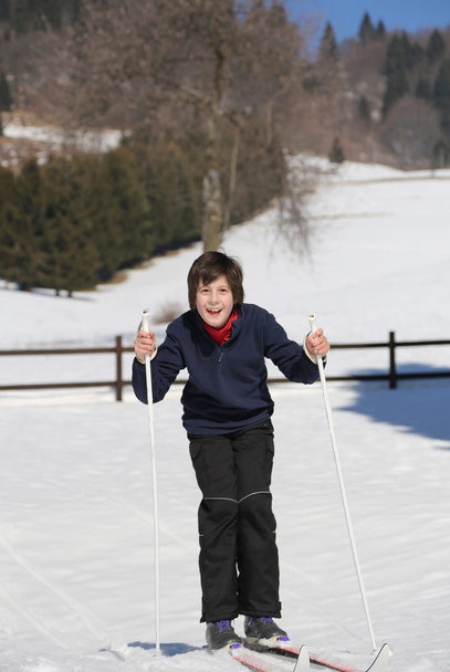 ребенок попробуйте беговые лыжи на белом снегу в горах
  - Фото, изображение