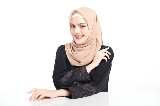 Красива молода азіатська мусульманка в бежевому хіджабі на білому тлі, Портрет арабської краси. - Фото, зображення