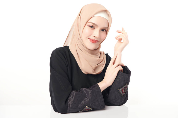 Schöne junge asiatische Muslimin trägt einen beigen Hijab auf weißem Hintergrund, Portrait of Arab Beauty. - Foto, Bild