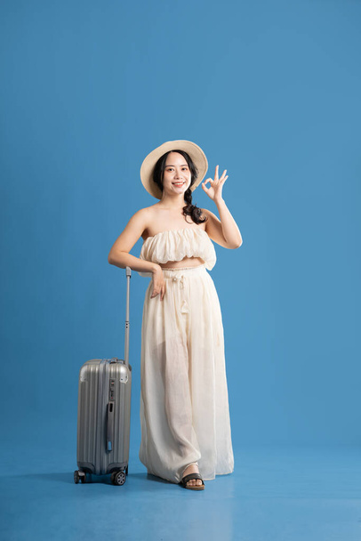 Ritratto di ragazza asiatica in posa su sfondo blu, in viaggio in estate - Foto, immagini
