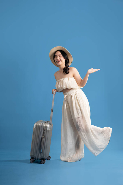 Portrait de fille asiatique posant sur fond bleu, voyageant en été - Photo, image