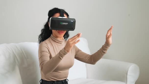 Молода жінка використовує окуляри віртуальної реальності вдома для вирішального досвіду покупок в Інтернеті. Інновації віртуальної реальності VR, оптимізовані для жіночого цифрового способу життя. - Кадри, відео