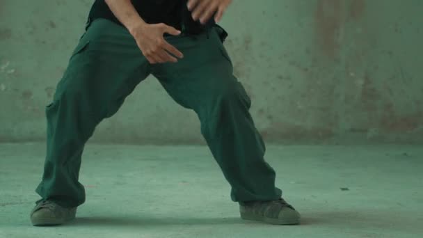Jóképű hipster gyakorló break tánc közben zenét hallgat fejhallgató cement háttérrel. Jóképű ázsiai utcai táncos robottáncol. Kültéri sport 2024. Modern tánc. hiphop. - Felvétel, videó